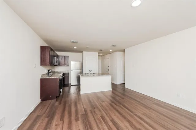 a view of kitchen with stainless steel appliances cabinets and wooden floor