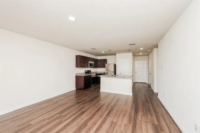 a living room with stainless steel appliances kitchen island wooden floor and view living room