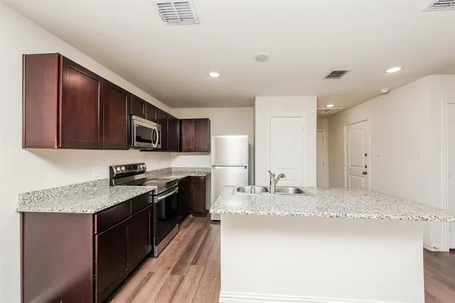 a kitchen with stainless steel appliances granite countertop a sink stove and refrigerator