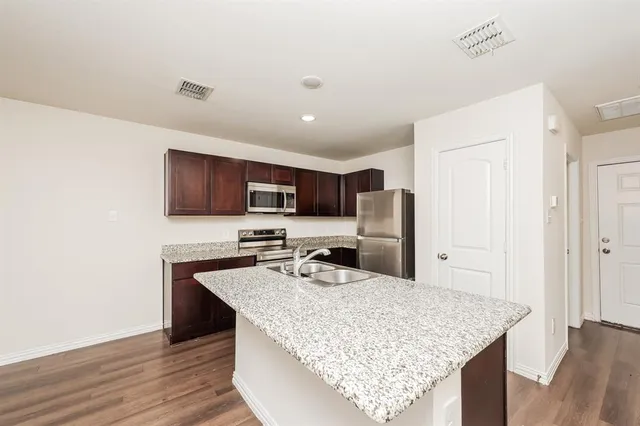 a kitchen with stainless steel appliances granite countertop a sink refrigerator and microwave