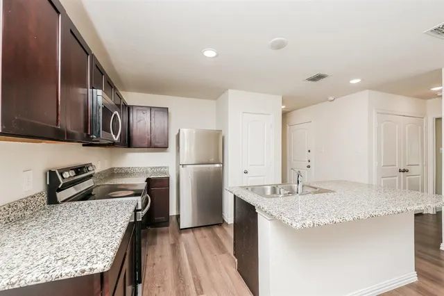 a kitchen with refrigerator and stove