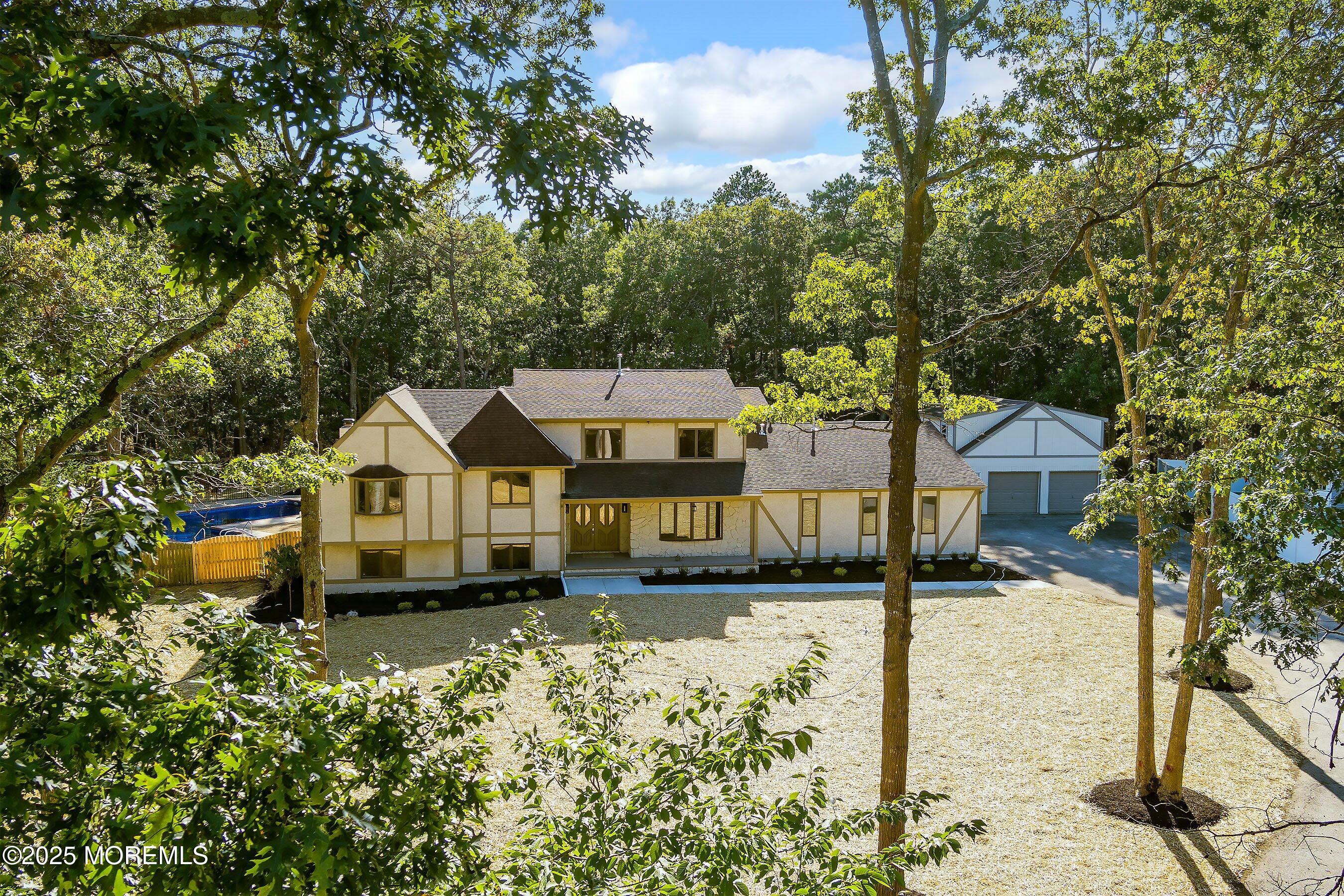 a front view of a house with a yard covered with trees