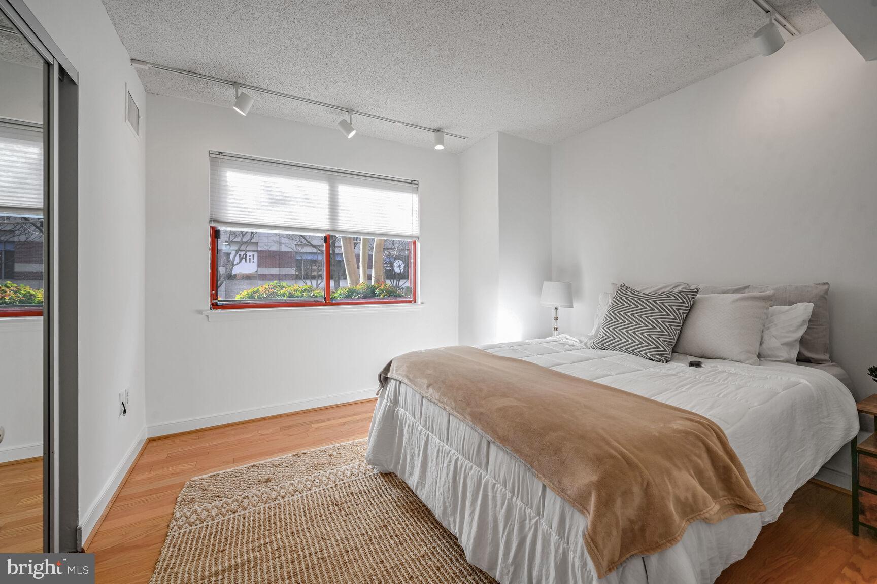 2301 N Street Northwest, Unit 104 Washington, DC 20037 - Photo 12 of 22 a bedroom with a bed and a window