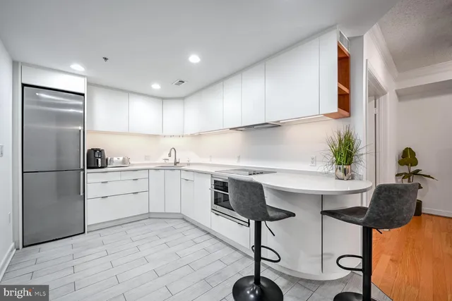 a kitchen with stainless steel appliances granite countertop a sink a stove a refrigerator and cabinets