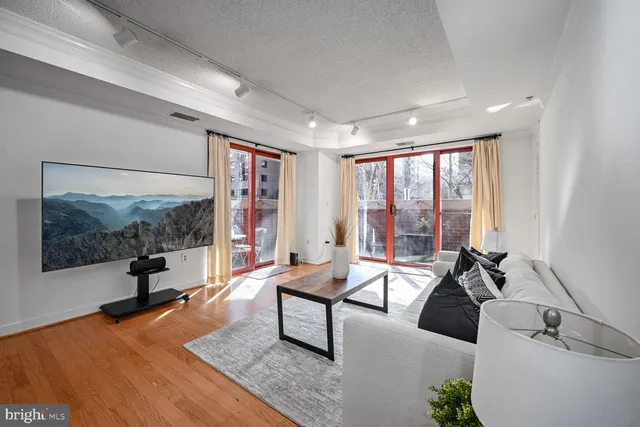 a living room with furniture large window and flat screen tv