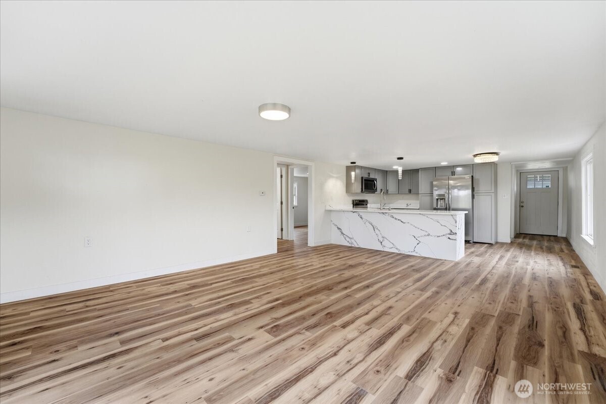 293 Barkley Road Manson, WA 98831 - Photo 7 of 40 a big room with wooden floor and kitchen view