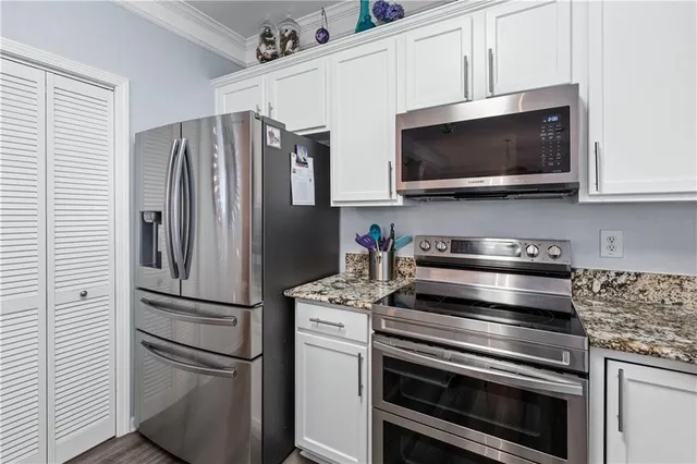 a kitchen with stainless steel appliances and white cabinets
