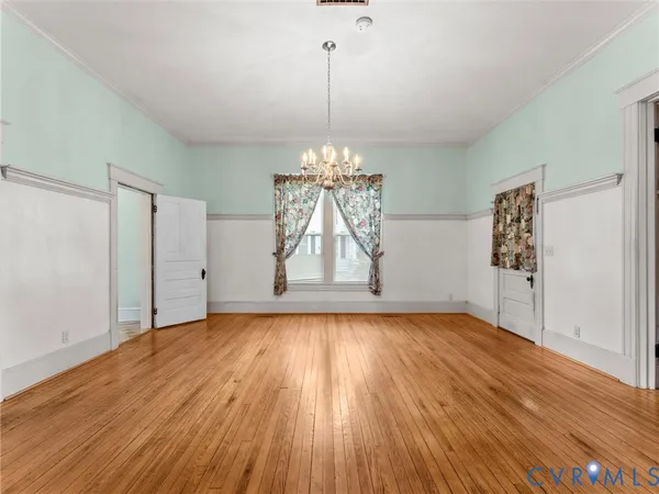 a view of empty room with wooden floor and window