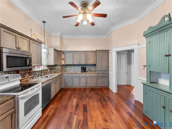 a kitchen with kitchen island granite countertop a sink appliances cabinets and a counter top space
