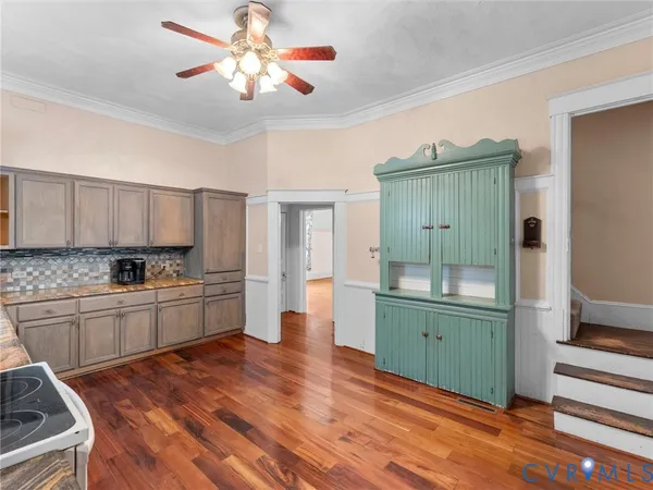 a kitchen with cabinets and wooden floor