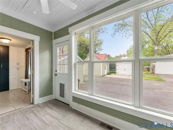 a view of an empty room with a window and wooden floor