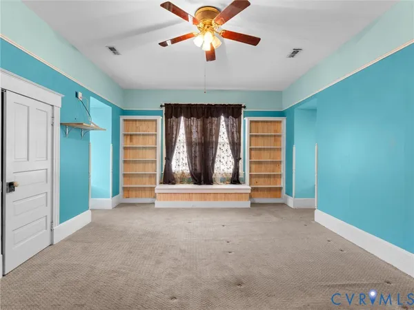 an empty room with closet and windows
