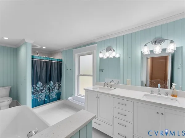 a bathroom with a double vanity sink a mirror and a bathtub