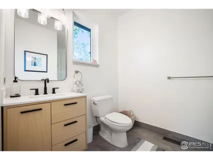 a bathroom with a toilet a sink and mirror