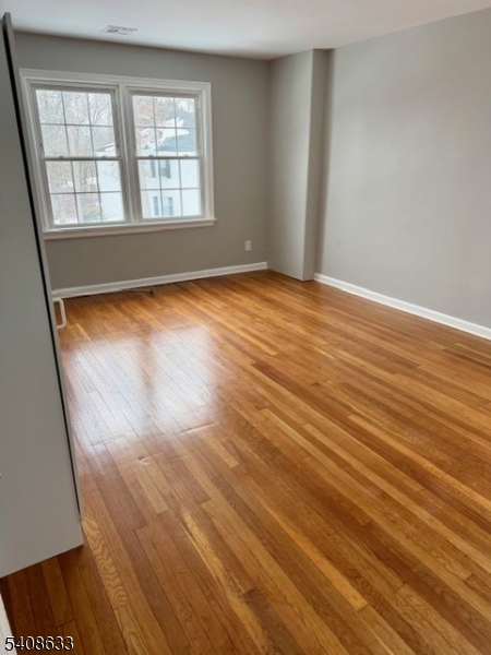 10 Beech Spring Drive, Unit 3A Summit, NJ 07901 - Photo 4 of 8 wooden floor in an empty room with a window