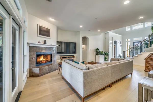 a living room with furniture a flat screen tv and a fireplace