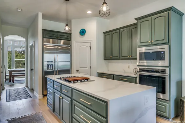 a kitchen with stainless steel appliances a stove a sink and a refrigerator