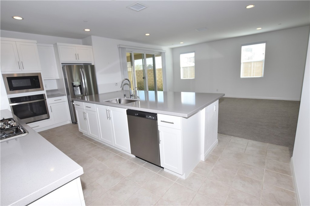 39824 Ninebark Court Temecula, CA 92591 - Photo 11 of 32 a room with kitchen island white cabinets appliances and furniture