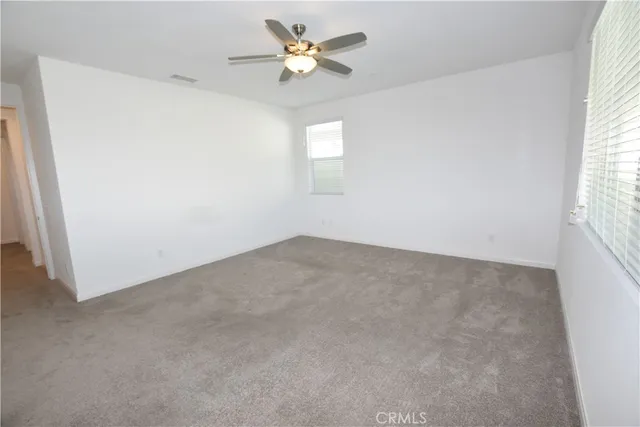 a view of an empty room with a fireplace and a window