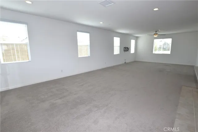 an empty room with a window and a ceiling fan