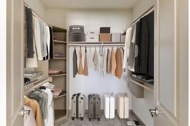 a view of walk in closet with clothes and shoes