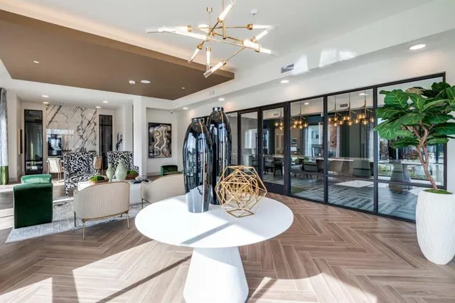 a living room with furniture a chandelier and a dining table with wooden floor