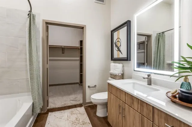 a bathroom with a granite countertop sink toilet and shower