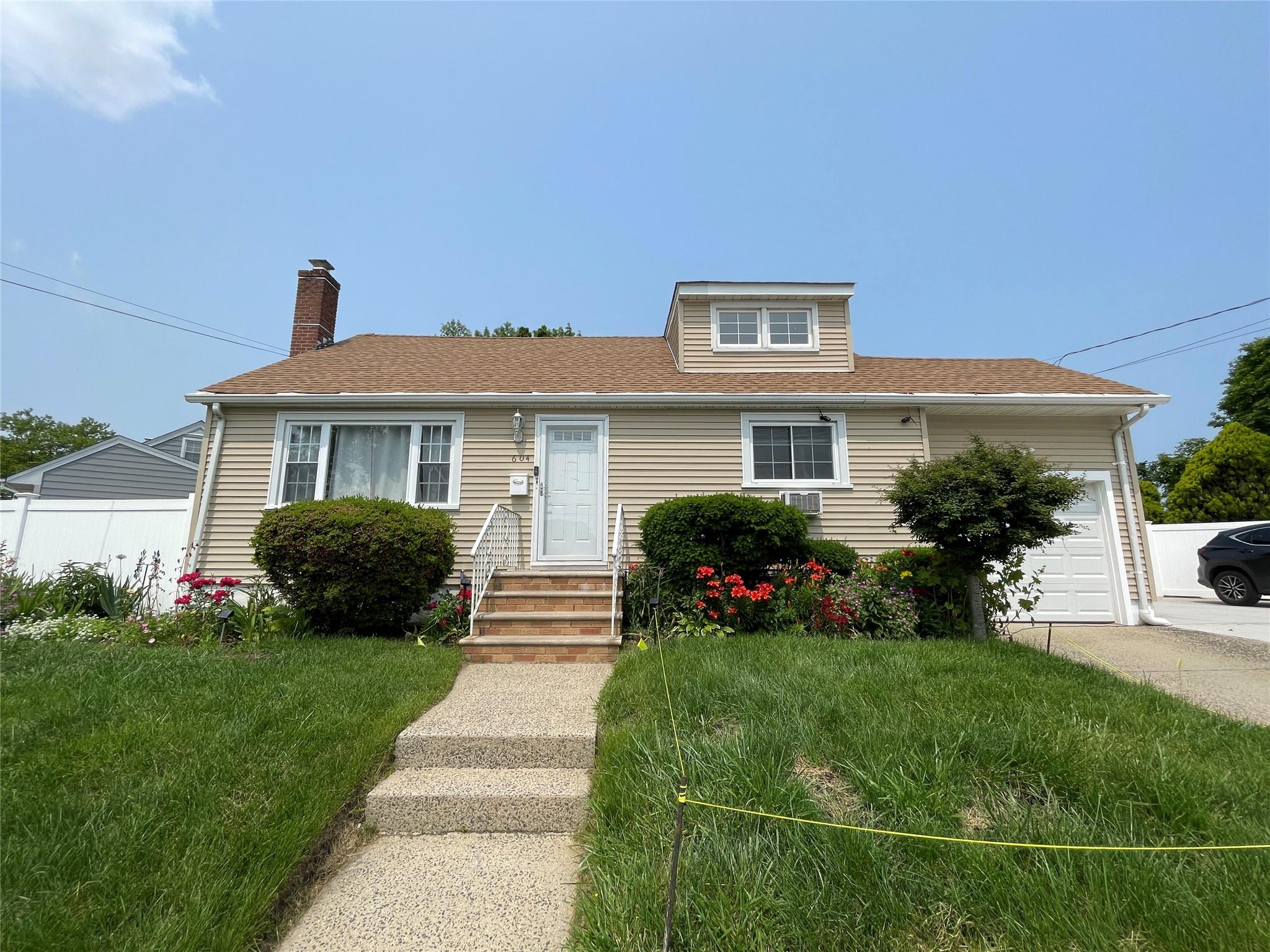 a front view of a house with a yard and potted plants