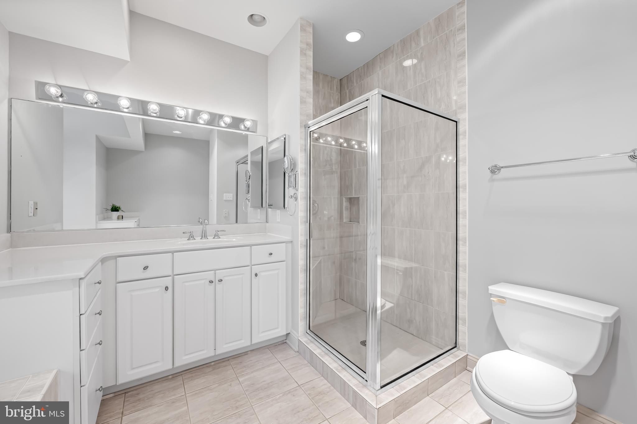 24 Roland Green, Unit 12 Baltimore, MD 21210 - Photo 29 of 53 a bathroom with a shower sink mirror and toilet