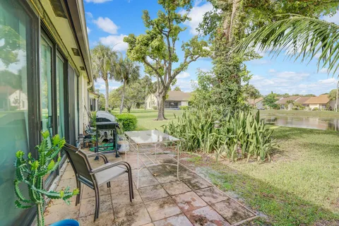 a view of a patio with table and chairs potted plants with floor to ceiling window