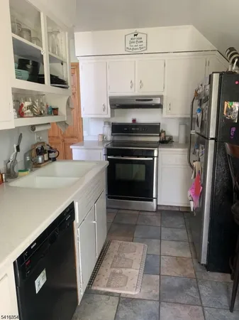 a kitchen with a sink and a stove top oven with wooden floor