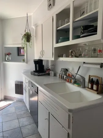 a kitchen with a sink a counter top space and cabinets