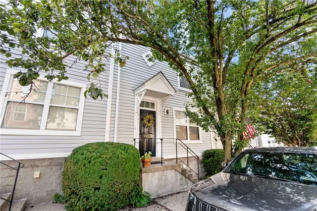 a front view of a house with a tree