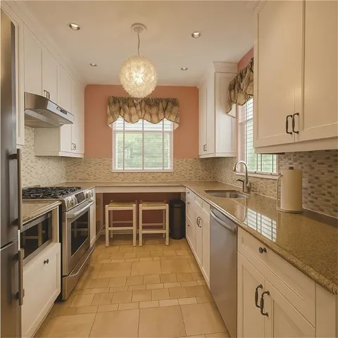 a kitchen with stainless steel appliances granite countertop a stove and a sink