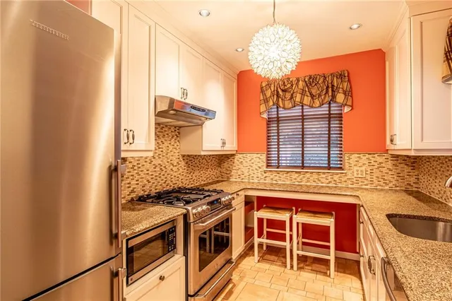 a kitchen with stainless steel appliances granite countertop a stove and a sink