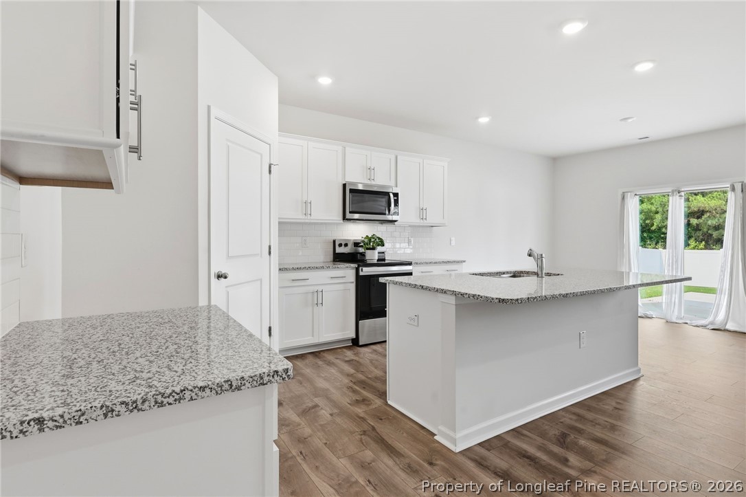 2208 Clydesmill Road Fayetteville, NC 28314 - Photo 12 of 26 a kitchen with stainless steel appliances granite countertop a sink stove and refrigerator