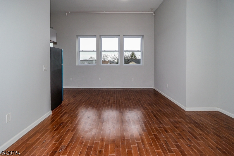 33 2nd Street, Unit 11 Raritan, NJ 08869 - Photo 4 of 7 an empty room with wooden floor and windows