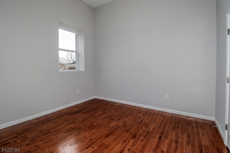 33 2nd Street, Unit 11 Raritan, NJ 08869 - Photo 5 of 7 a view of an empty room with wooden floor and a window