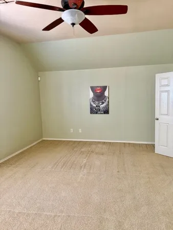 an empty room with a ceiling fan and painted walls