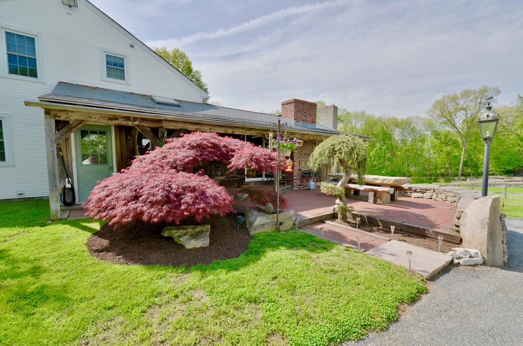 41 Rawson Road Webster, MA 01570 - Photo 7 of 30 a view of a patio with a table and chairs under an umbrella
