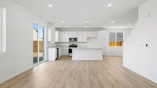 a large kitchen with stainless steel appliances kitchen island a large counter top and a refrigerator
