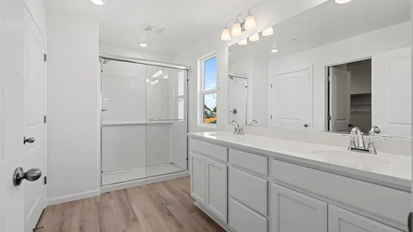 a bathroom with a double vanity sink mirror and shower