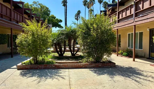 a view of a building with trees and flowers