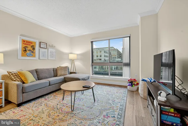 a living room with furniture a flat screen tv and a window