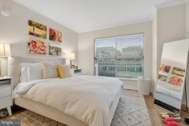 a bedroom with a bed a dresser next to a window