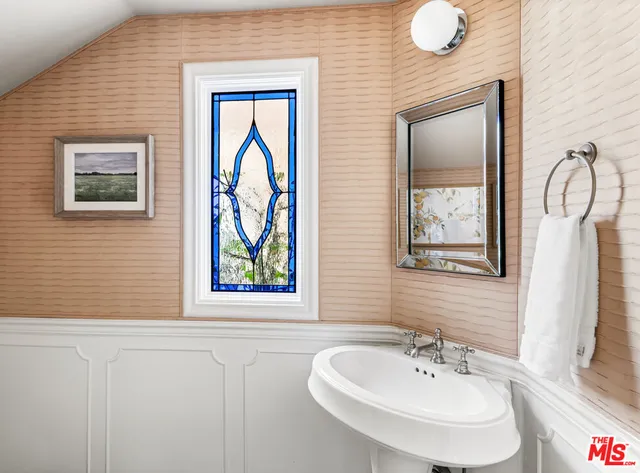 a bathroom with a sink mirror and a window