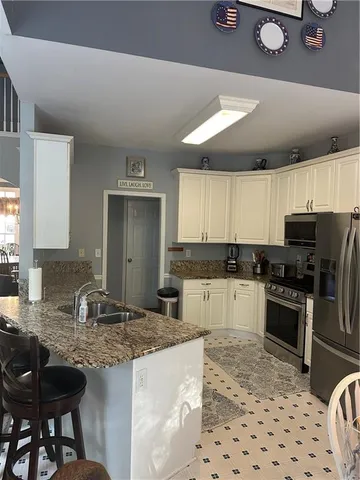 a kitchen with granite countertop a sink stainless steel appliances and cabinets