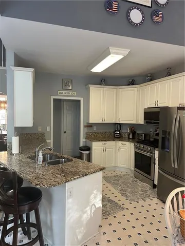 a kitchen with granite countertop a sink stainless steel appliances and cabinets