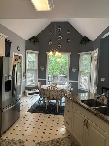 a kitchen with granite countertop a sink stove and refrigerator