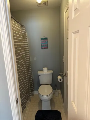 a bathroom with a toilet and a shower curtain